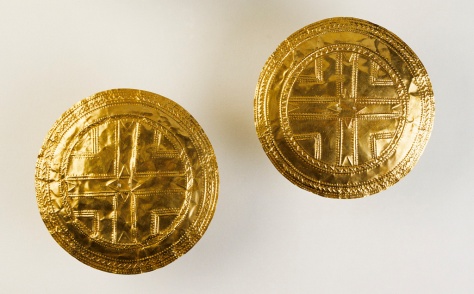 Pair of gold discs, Tedavnet, Co. Monaghan. Early Bronze Age, 2200â€“2000 bc. Discovered in the roots of an old tree, this pair of discs is the largest and most sophisticated of the Early Bronze Age discs known from Ireland. A complex arrangement of raised lines, rows of dots and zig-zags has produced a central cross surrounded by concentric patterns similar to other discs but much more elaborate in composition and, technically, far superior. The combination of the techniques of repoussÃ©, punching and polishing, together with the slight doming of the surfaces, highlights and gives a depth and texture to the discs not seen on other pieces. 1872:34, 35. D. 11.3 and 11.5 cm; Wt. 22.5 and 22.8 g.Armstrong 1920, 84; Cahill 1983, no. 6.